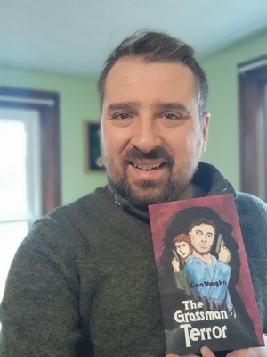 Author Leo Vaughn holding a copy of The Grassman Terror