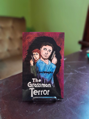 The Grassman Terror - paperback book on a stand